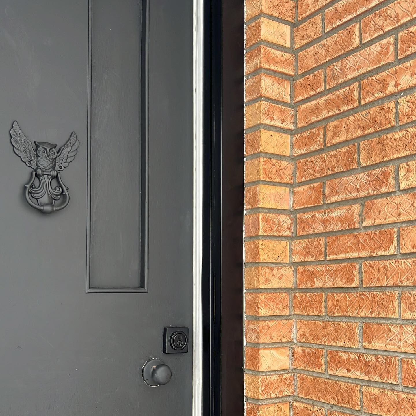 Black front door and brick exterior after an entry transformation